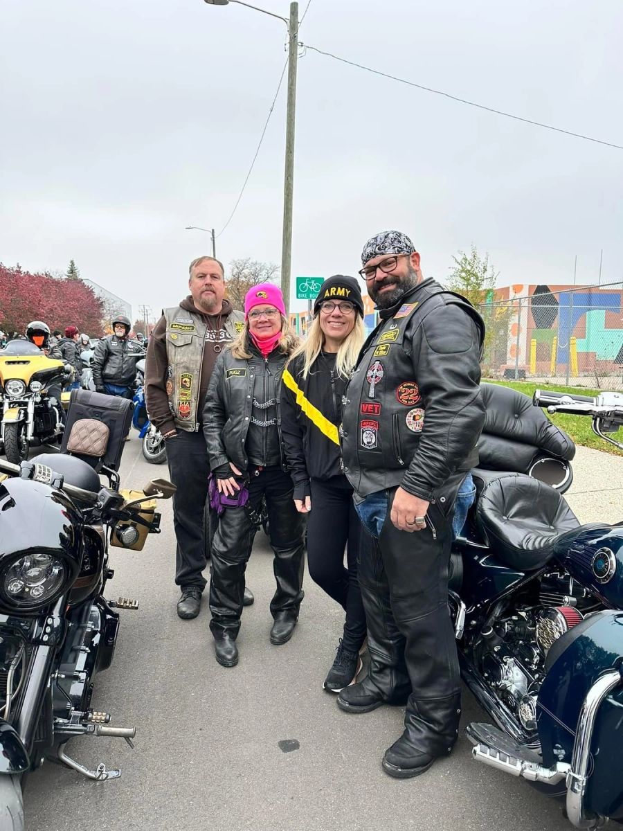 Four members with their motorcycles on a street