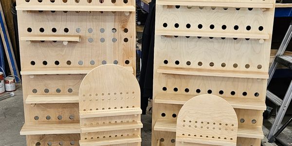 Wooden display stands with peg holes and shelves.