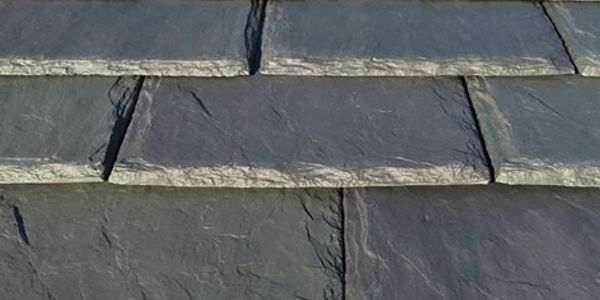 Close-up of textured gray slate roof tiles arranged in rows.