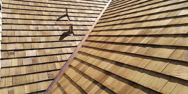 Close-up view of a wooden shingle roof with a metal bracket.