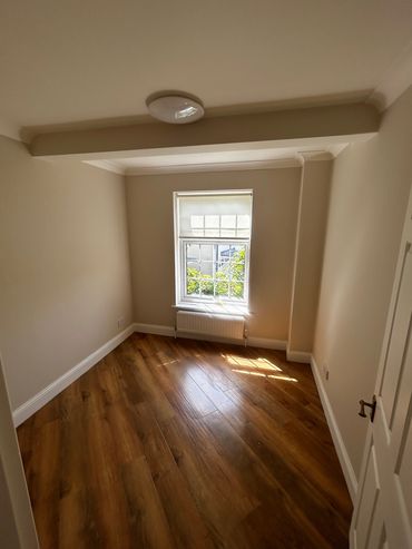 Empty room with wooden floor and window.
