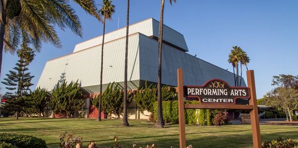 Performing Arts Center building with palm trees on a sunny day.