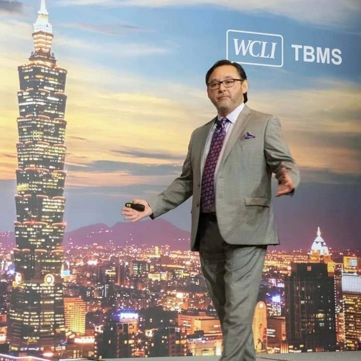 Professional man presenting in front of a cityscape backdrop.