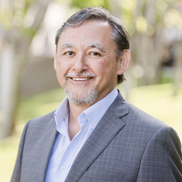 Smiling businessman in suit outdoors.