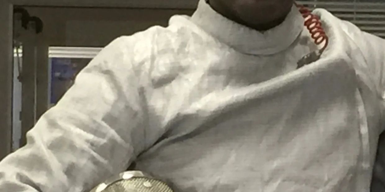 Person wearing a white fencing jacket.