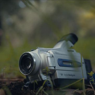 Camera laying on ground in forest
