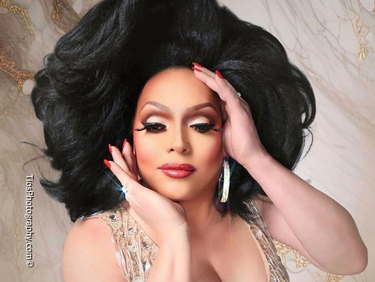 Person with glamorous makeup and voluminous black hair.