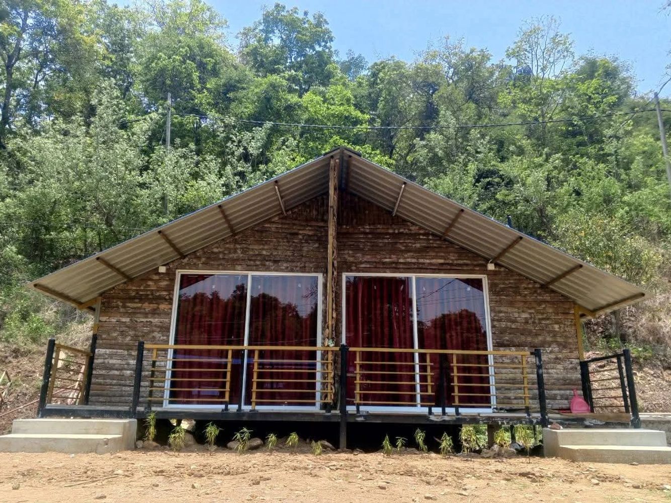 Wooden cabin with a double sliding glass door and a metal roof.