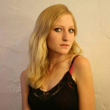 Picture of me in my early twenties. My hair is long and blonde, and I'm wearing a black lacey shirt. 