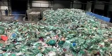 Large pile of plastic waste in a recycling facility.