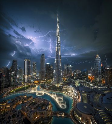 burj khalifa with lightning strikes at the background - photo by ahmad alnaji