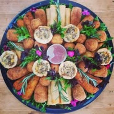 Platter of assorted appetizers with dipping sauce and garnishes.