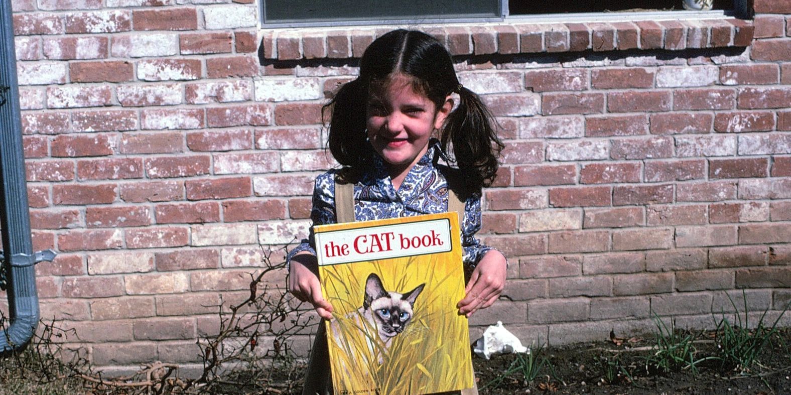 Young girl holding a cat book