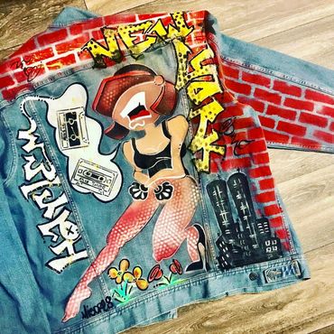 Denim jacket with colorful graffiti art and text.