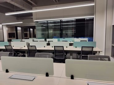 Spacious coworking space with collaborative desks, natural lighting, and a dynamic work environment.