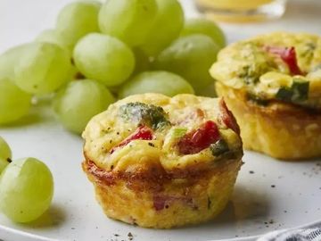 Mini vegetable and cheese frittatas with green grapes on the side.