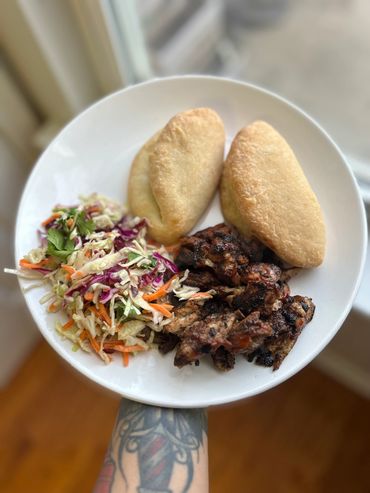 Plate with fried chicken, two bread rolls, and fresh coleslaw.