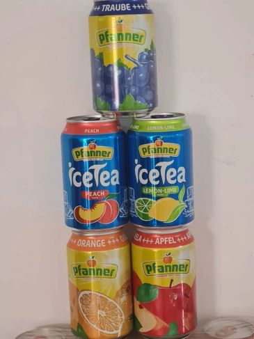 Stacked cans of Pfanner iced tea in various fruit flavors.