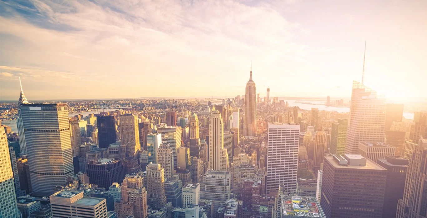 Sunlit skyline of New York City with iconic skyscrapers.