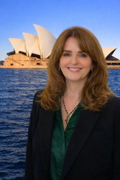 Woman smiling in front of Sydney Opera House.