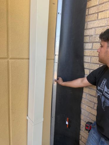 Man pointing at a panel on the wall.