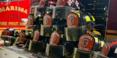 Line of firefighter helmets with Marissa labels.