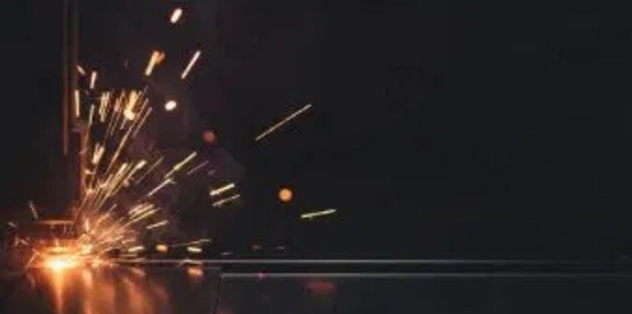 Bright sparks flying from a welding process in a dark setting.