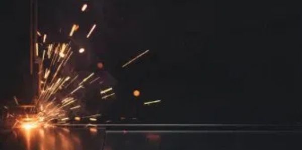 Bright sparks flying from a welding process in a dark setting.