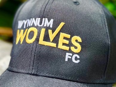 Embroidery decoration on a black event cap.  Embroidered Wynnum Wolves Football Club Logo.