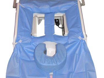 Medical examination chair with blue padded covers and face rest.