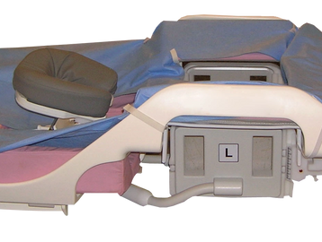 Medical examination chair with padded sections and adjustable parts.