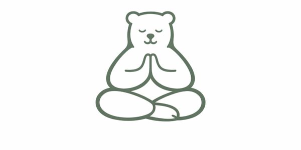 A bear sitting cross-legged in meditation with hands together.