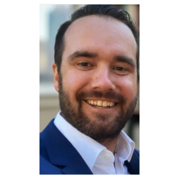 Smiling man in a suit and white shirt.