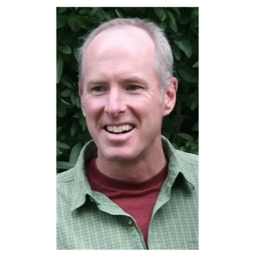Smiling man outdoors in casual clothes.