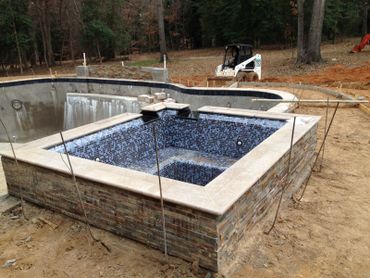 pool, spa with one inch tile inside, travertine coping, ledger stone, with two granite spillovers