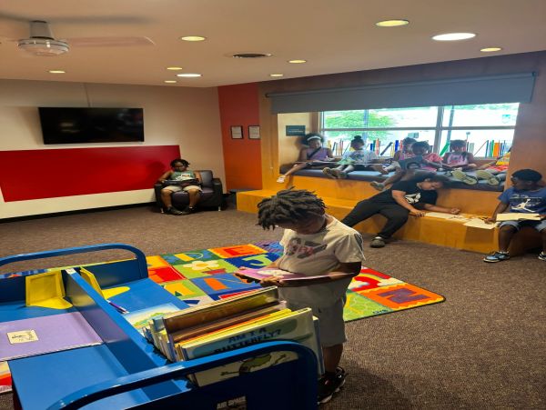 Children reading books in a colorful library area.