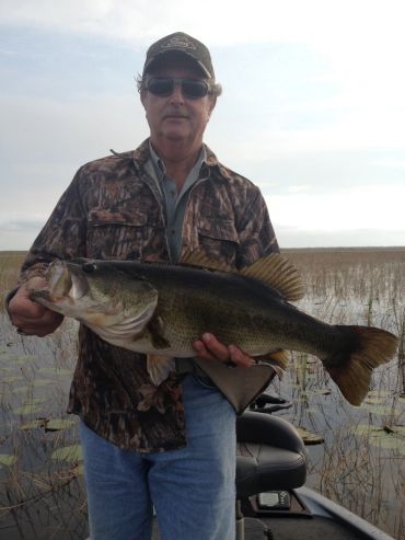 Man holding a large fish on a boat.
