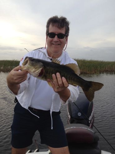 Man holding a large fish on a boat.