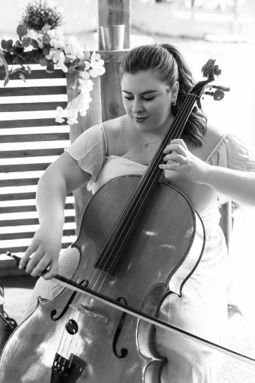 Woman playing cello with focus.