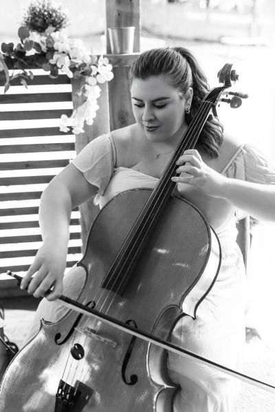 Woman playing cello outdoors.