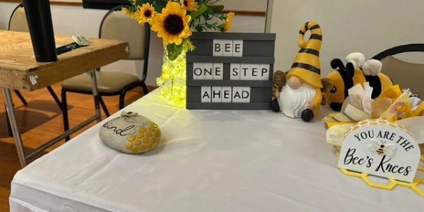 Decorated table with bee-themed items and motivational signs.