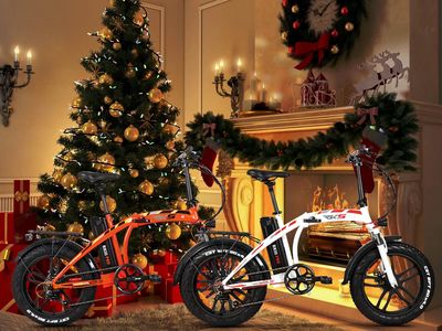 two electric bikes sitting in front of a Christmas tree