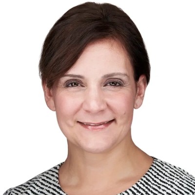 Professional headshot of a smiling woman with dark hair against a white background.