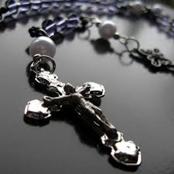 Silver Catholic rosary with crucifix, a sacramental for spiritual warfare.