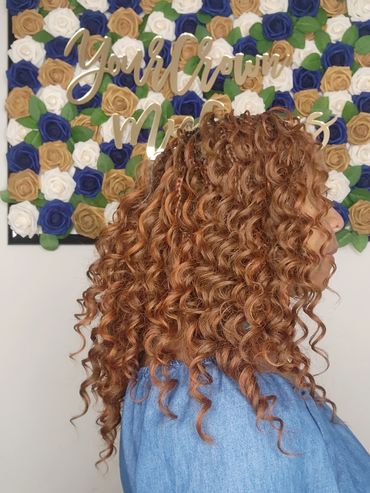 Side view of a woman with long, curly hair.