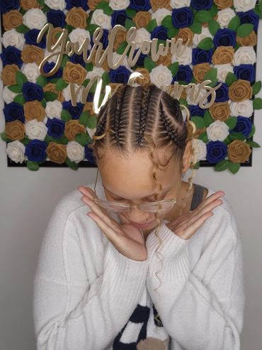 Person with braided hair posing shyly.