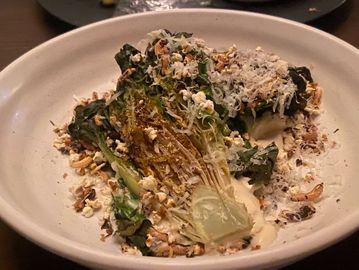 Grilled romaine lettuce topped with grated cheese and crunchy bits.