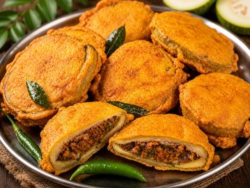 A plate of spicy stuffed Indian snacks garnished with curry leaves and green chilies.