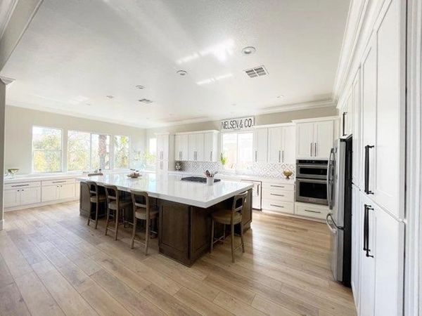 Crown Cabinets: Capri door in Maple wood w/ Designer White paint for perimeter & Alder wood with Mus