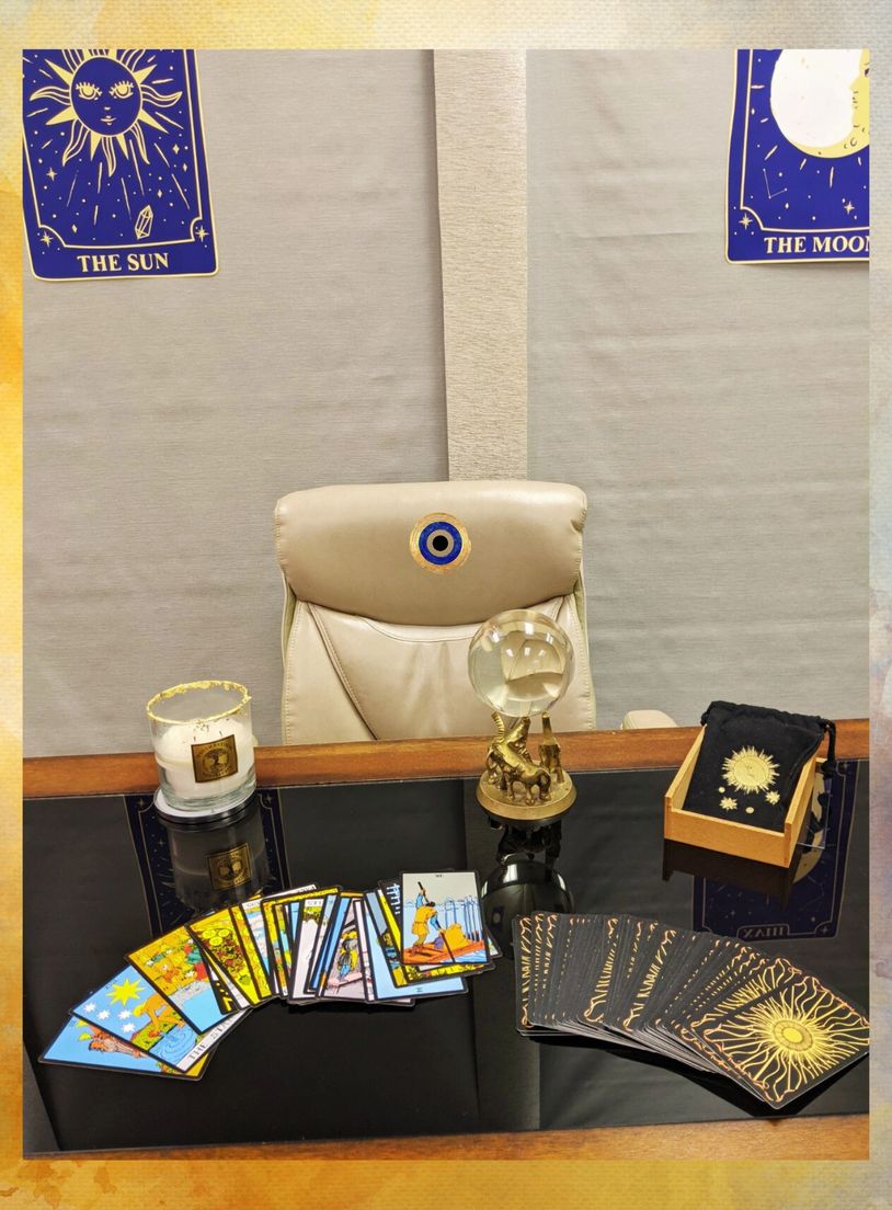 Tarot cards, Crystal ball and Candle displayed on a desk with tarot cards in the background 